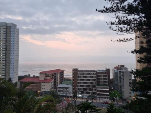 a city with buildings and the ocean in the background at Ocean Village in Amanzimtoti