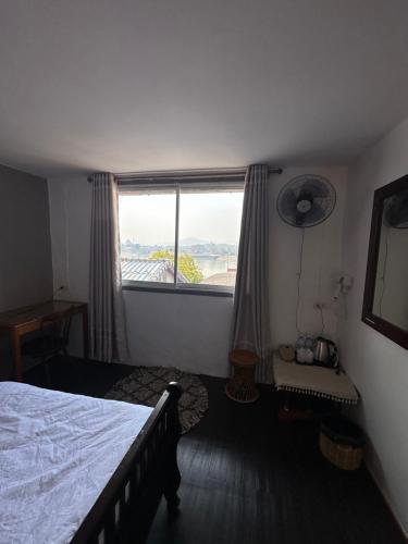 a bedroom with a bed and a large window at THADAN GUEST HOUSE in Ban Houayxay