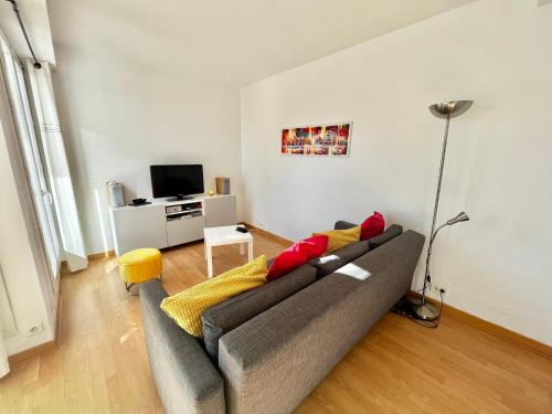 un salon avec un canapé et une télévision dans l'établissement Appartement T2 avec parking, climatisé à 7 min de la plage - La Grande Motte Centre Ville - FR-1-716-36, à La Grande Motte