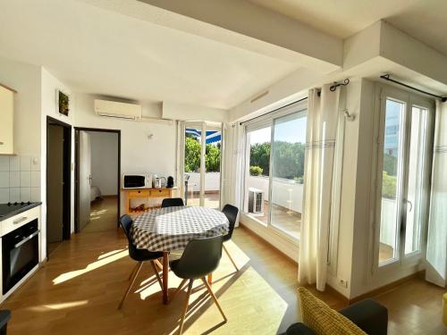 une cuisine et une salle à manger avec une table et des chaises dans l'établissement Appartement T2 avec parking, climatisé à 7 min de la plage - La Grande Motte Centre Ville - FR-1-716-36, à La Grande Motte