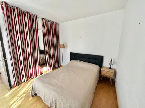 une chambre avec un lit et une grande fenêtre dans l'établissement Appartement T2 avec parking, climatisé à 7 min de la plage - La Grande Motte Centre Ville - FR-1-716-36, à La Grande Motte
