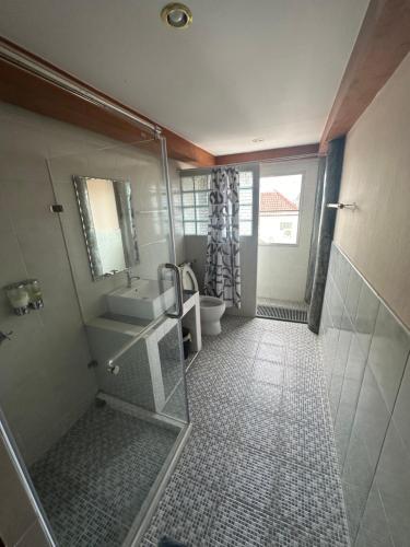 een badkamer met een douche, een wastafel en een toilet bij Mona House Phuket in Ban Na Bon