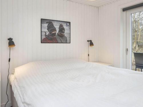 a bedroom with a white bed and a picture on the wall at Holiday home Fanø VIII in Fanø