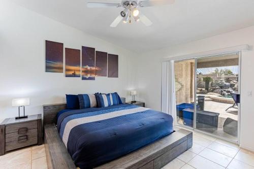 a bedroom with a large bed and a sliding glass door at HavaMemorable Stay Pool Spa Firepit VIEWS! in Lake Havasu City