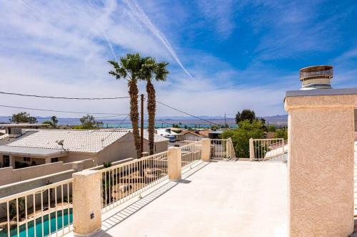 a balcony with a fence and palm trees at HavaMemorable Stay Pool Spa Firepit VIEWS! in Lake Havasu City