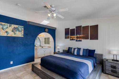 a blue bedroom with a bed and a ceiling fan at HavaMemorable Stay Pool Spa Firepit VIEWS! in Lake Havasu City