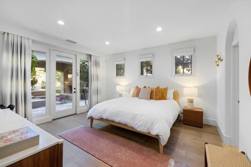 a bedroom with a large white bed and windows at @ Marbella Lane - 4BR Mediterranean-style Home in Newport Beach