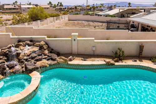a large swimming pool in a yard next to a house at HavaMemorable Stay Pool Spa Firepit VIEWS! in Lake Havasu City
