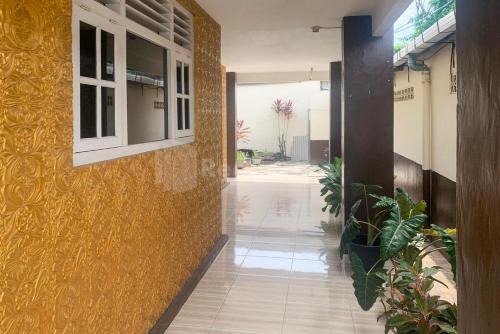 un pasillo de un edificio con una pared amarilla en Asyura Kostel Syariah Redpartner, en Kedaton
