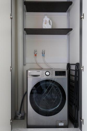 a washer and dryer in a kitchen with a shelf at Wecostay Gangnam in Seoul