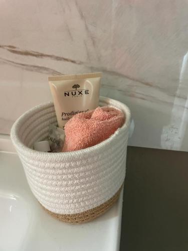 a white basket with a bar of soap in it at Prestige Spa Cayenne T2 in Cayenne