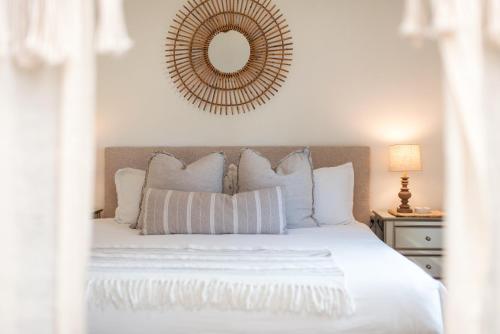 a bedroom with a white bed with a mirror on the wall at Le Petit Guesthouse -King Bed Walk to Whitworth in Nine Mile Falls