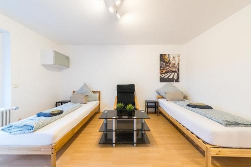 two beds in a room with a table at NEW Luxury Apartment in Heilbronn, Ludwigsburg, Backnang, Stuttgart in Beilstein