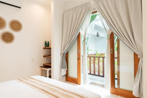 a bedroom with a bed and a large window at Naia Lombok in Kuta Lombok