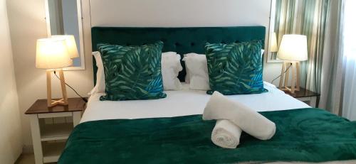 a bedroom with a green bed with two lamps at Durban Point Waterfront, 505 Quayside 40 Canalquay Rd in Durban