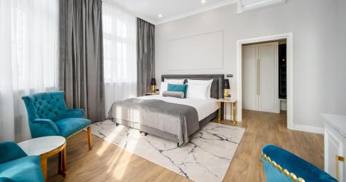 1 dormitorio con 1 cama y 2 sillas azules en Hotel Pavco en Gorzów Wielkopolski