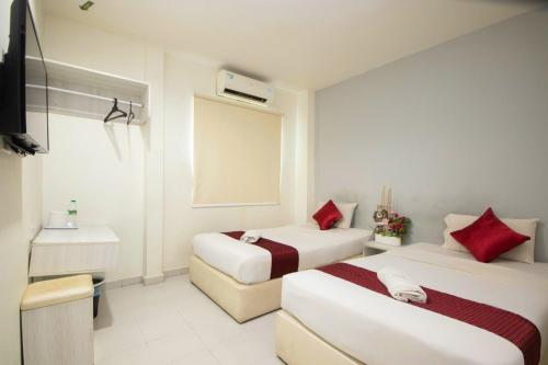 a hotel room with two beds and a sink at Sun Inns Hotel Kota Laksamana Melaka in Melaka
