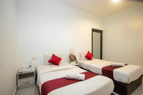 two beds in a room with red pillows at Sun Inns Hotel Kota Laksamana Melaka in Melaka