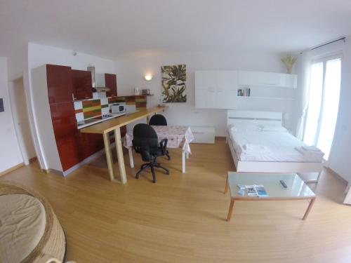 a living room with a desk and a table at Studio Apartment Open Space with Terrace in Argegno