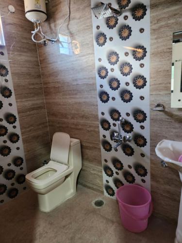 a bathroom with a toilet and a sink at Manidweepa farm house in Venkatāpur