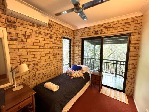 a room with a bed and a brick wall at Avalon in Arcadia