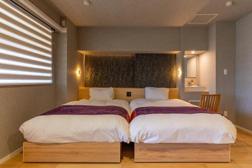 two beds sitting next to each other in a bedroom at TKP Lectore Hakone Gora in Hakone