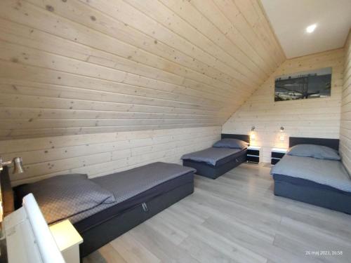 two beds in a room with wooden walls at New holiday homes with a swimming pool, Rewal in Rewal