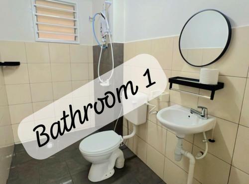 a bathroom with a toilet and a mirror and a sink at JC Homestay Gamuda SkyLuge KL 1 in Rawang