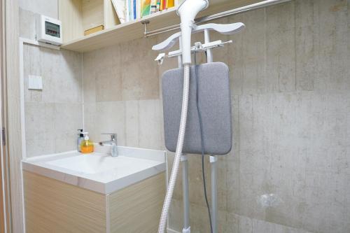 a bathroom with a sink and a shower with a towel at Paco Hotel Guangzhou North Railway Station in Huadu