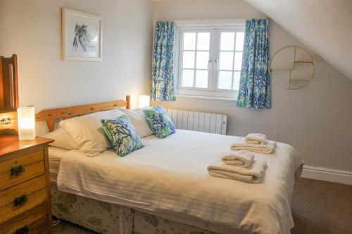 a bedroom with a bed with towels on it at Waders in Salcombe