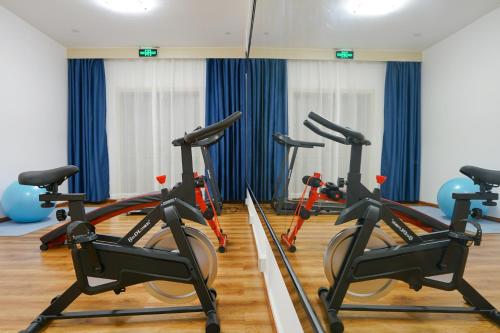 a gym with three exercise bikes in a room at Paco Hotel Guangzhou North Railway Station in Huadu