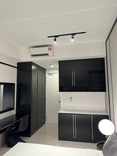 a living room with black cabinets and a tv at Axon Suites KL Pavilion in Kuala Lumpur