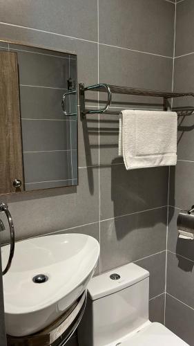 a bathroom with a sink and a toilet and a mirror at White Lodge in Pantai Cenang