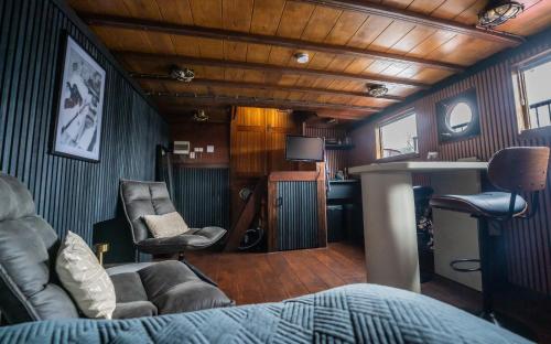 uma sala de estar com um sofá e uma secretária em Houseboat-Amsterdam-Classic em Amsterdã