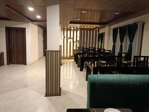 Bomdila的住宿－Hilsan Hotel，用餐室设有桌椅和窗户。