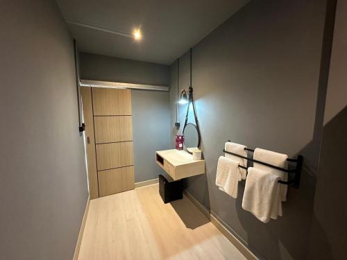 a bathroom with a sink and a mirror and towels at Bangkok vibe, City House, 7 mins to BTS, City center, Private room in Sathon, Private bathroom, Bangkok, Thailand in Bangkok