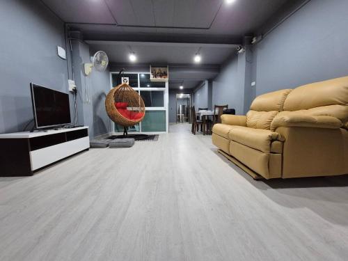 a living room with a couch and a television at Bangkok vibe, City House, 7 mins to BTS, City center, Private room in Sathon, Private bathroom, Bangkok, Thailand in Bangkok