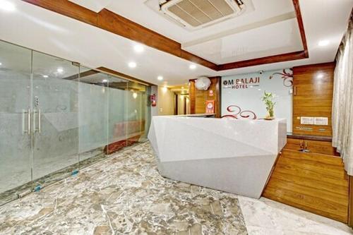 a bathroom with a glass shower and a sink at Hotel Om Balaji in Ahmedabad