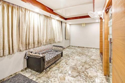 uma sala de estar com um sofá e uma janela em Hotel Om Balaji em Ahmedabad