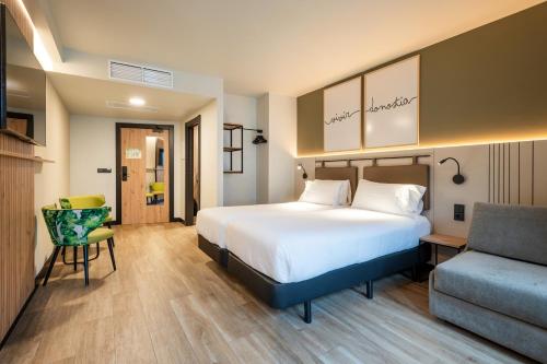 una camera d'albergo con letto e sedia di Leonardo Boutique Hotel San Sebastián a San Sebastián