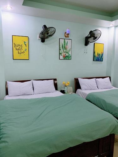 two beds sitting next to each other in a bedroom at Long Guest House in Cat Ba