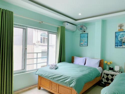 a bedroom with blue walls and a bed with a window at Long Guest House in Cat Ba