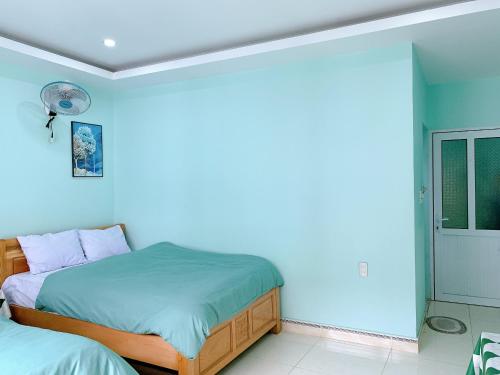 a bedroom with two beds and a blue wall at Long Guest House in Cat Ba