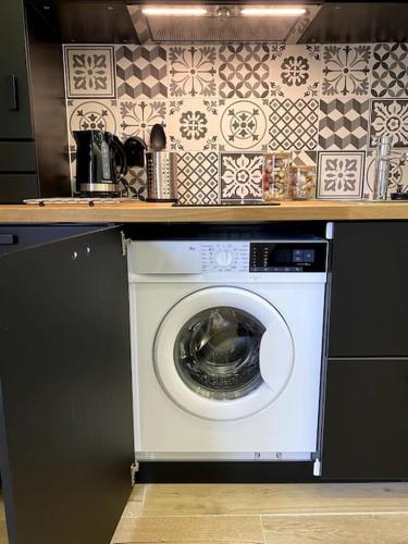 a washing machine under a counter in a kitchen at BLACK TOUCH STUDIO - FIBRE*PARKING*NEAR BASEL in Saint-Louis