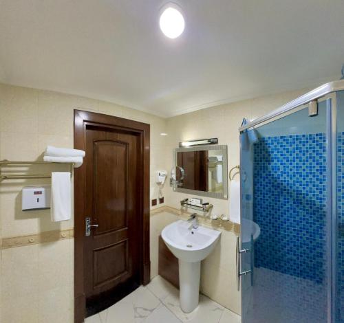 a bathroom with a sink and a shower at Hayot Hotel in Tashkent