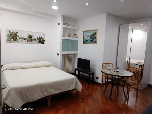 1 dormitorio con cama y mesa pequeña en Monovano Eumorfia, en Triggiano