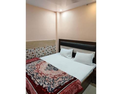 a bedroom with a bed with white sheets and pillows at Hotel Avenue, Kanpur in Kānpur