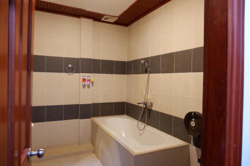 uma casa de banho com uma banheira e um lavatório em Kongmany Prestige Hotel em Muang Không