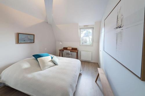 une chambre blanche avec un lit et une table dans l'établissement Plage à pied - 3 balcons - 3 chambres - Parking, à La Baule