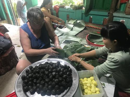 two women are looking at a bowl of blackberries at Monkeyland Cham island Homestay in Tân Hiệp